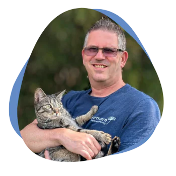 Mann mit Brille und Katze auf dem Arm