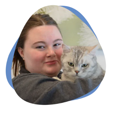 Junge Frau mit dunklen Haaren und einer Katze auf dem Arm